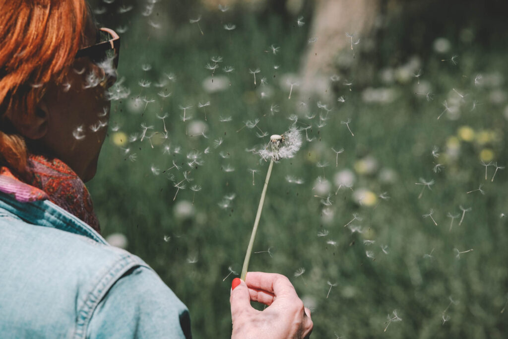 eine Frau mit einem Löwenzahn